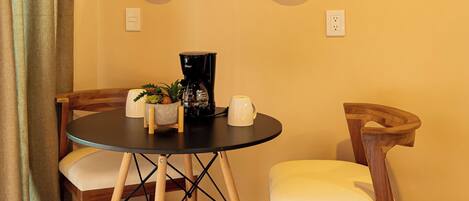 A room with a round table, two chairs, and three wall-mounted mirrors.