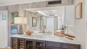 Una cocina moderna con encimeras de mármol, armarios de madera y una isla central.