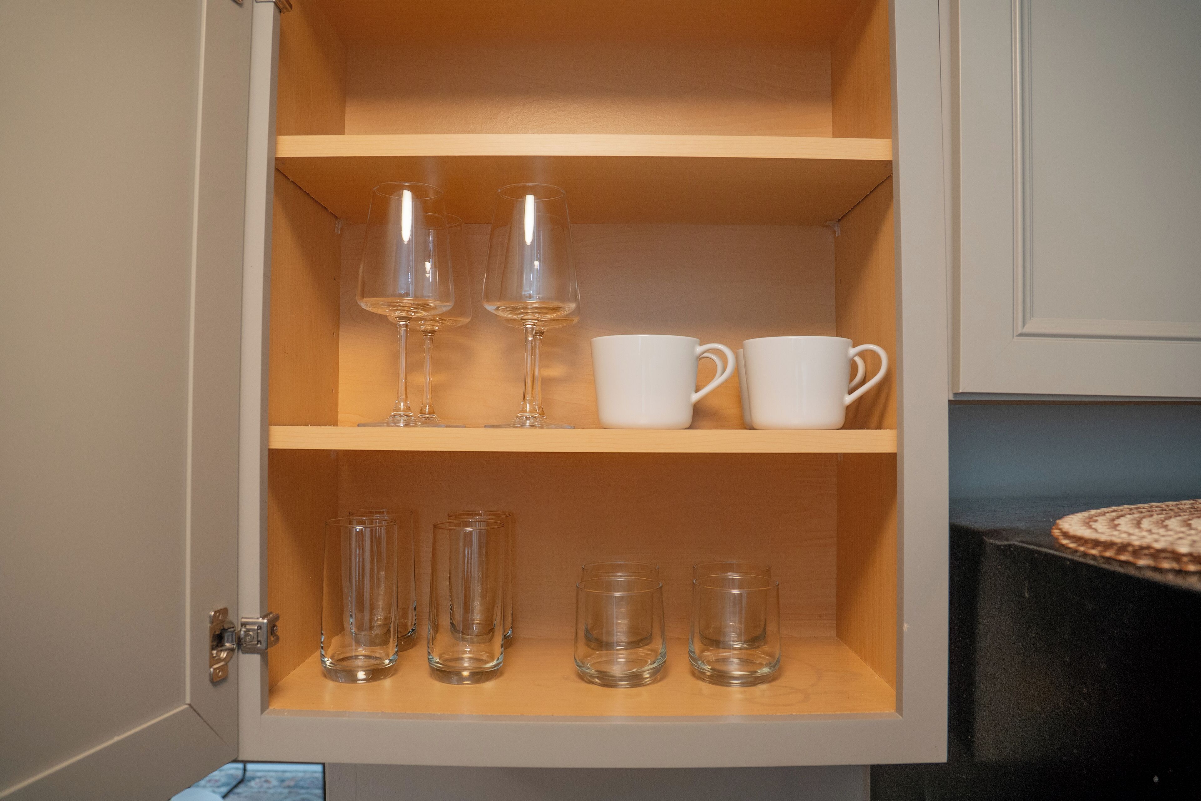 A cabinet with shelves containing various glassware.