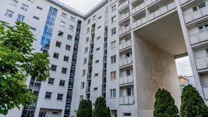 Een meerlaags woongebouw met balkons en grote ramen.