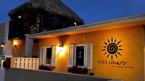 A building with a thatched roof, a sun logo, and the text "Solimar Villas Aruba".