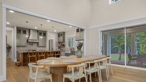 Una cocina moderna con una isla central, sillas de madera y un gran comedor.