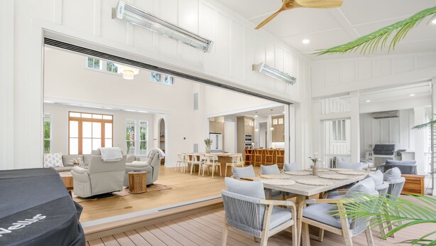 Un amplio espacio habitable con piso de madera, una mesa de comedor y un sofá.