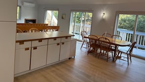 Una cocina amplia con comedor, ventanas grandes y vistas al exterior.