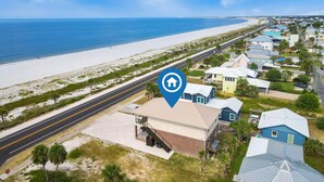 Luchtbeeld van een kustgebied met huizen, een strand en een weg.