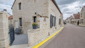 A stone building with a small balcony, a bench, and a yellow curb. - Gite Seigneurial - LES RICEYS (LES RICEYS)