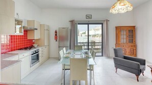 Eine moderne Küche mit Essbereich, ein Balkon mit Blick und ein Holzkabinett.