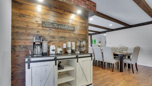 Un coin repas rustique avec un mur en bois, un espace dédié au café et une table à manger avec des chaises.