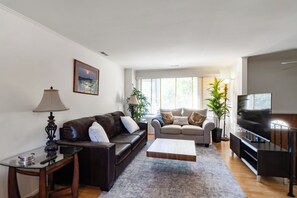 A living room with a sofa, a coffee table, and a television.