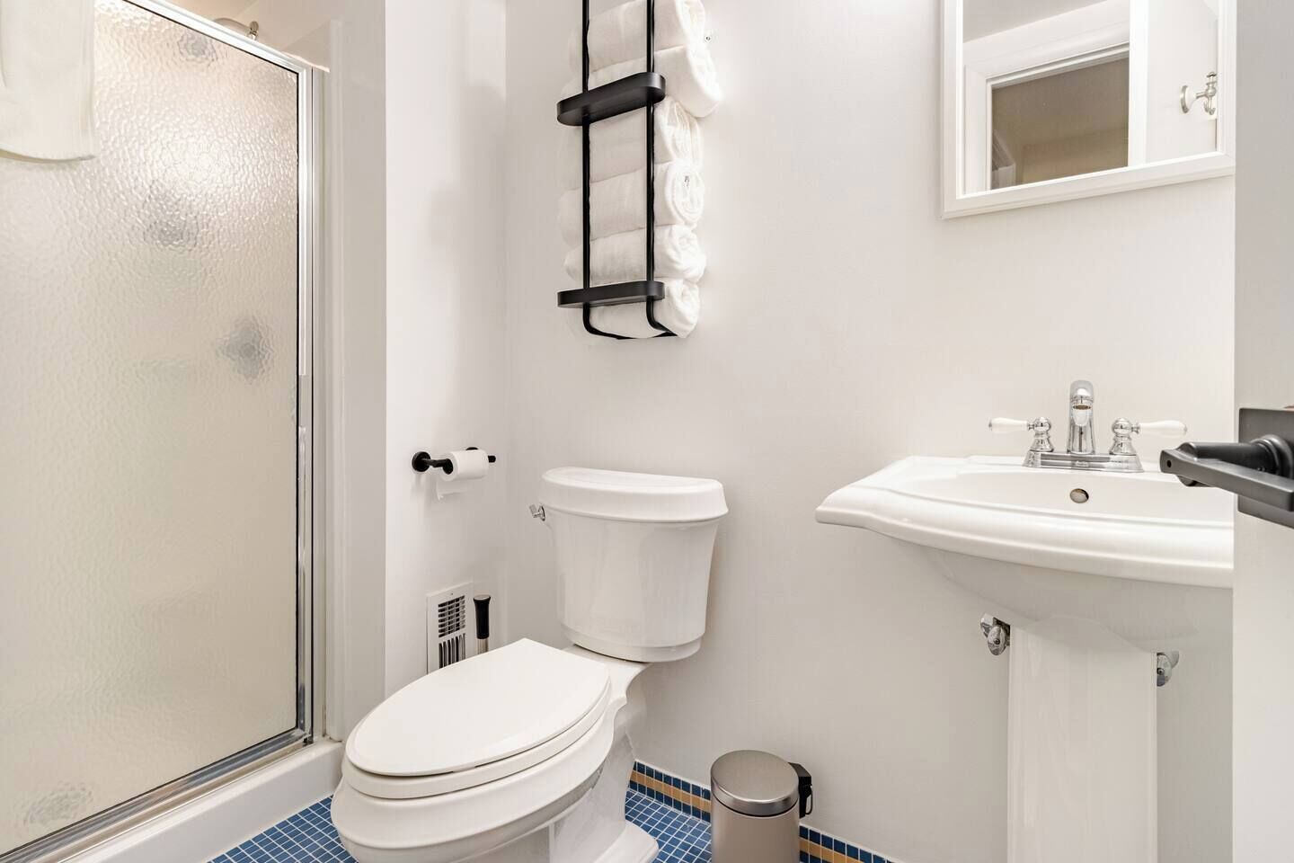 Une salle de bain comprenant des toilettes, un lavabo et un espace douche.