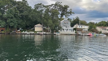 Une propriété au bord du lac, comprenant une grande maison, un quai et des bateaux.