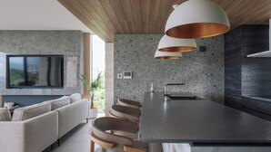 A modern kitchen with a central island, a built-in oven, and a large window. - CELEVI NANJO (Nanjo)