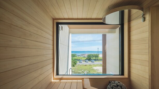 A wooden interior with a large window, a built-in bench, and a small seating area. - CELEVI NANJO (Nanjo)