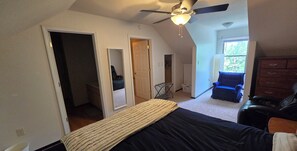 A bedroom with a bed, a ceiling fan, a window, and a door leading to another room. - Cozy Cabin Greers Ferry Lake View (Clinton)