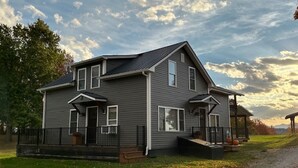 Une maison à deux étages avec un porche à l’avant, un hall d’entrée couvert et une petite terrasse.