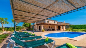 Un espace aménagé au bord de la piscine, avec des chaises longues et une piscine.