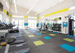 A gym with treadmills, weight machines, and exercise mats.