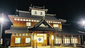 A traditional Japanese building with a wooden facade, tiled roof, and a central entrance with a wooden gate. - Suzukagojo (Nagahama)