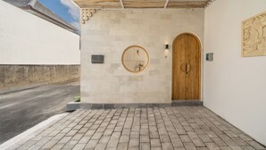L'ingresso di un edificio con una porta in legno, uno specchio circolare e una targa con scritto "Rameau".