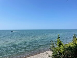 Une mer calme, avec un bateau s’éloignant de la côte.