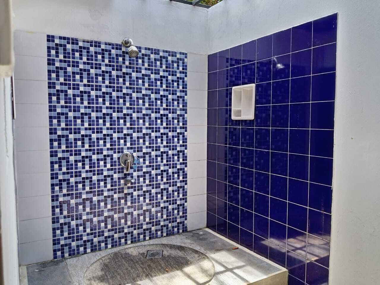 Un baño con pared de mosaicos, una bañera y zona de ducha.