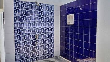 Un baño con pared de mosaicos, una bañera y zona de ducha.