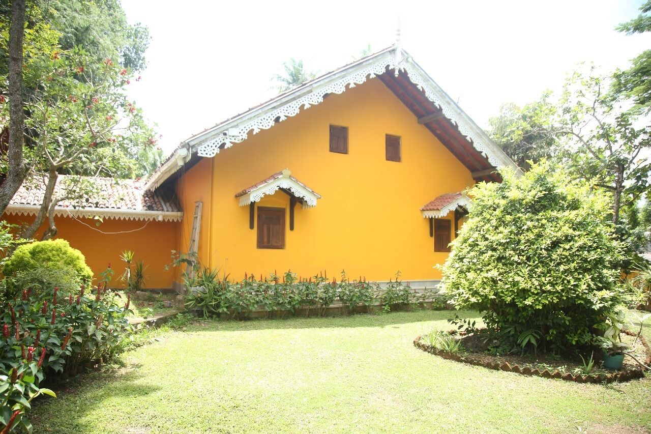 Una casa gialla con tetto in tegole e un piccolo portico.