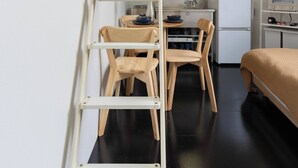 A compact room with a bunk bed, a desk with a chair, a microwave, and a refrigerator. - House Hotel nakano TNA (Tokyo)
