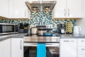 A modern kitchen with stainless steel appliances, a microwave, a stove, and a coffee maker.