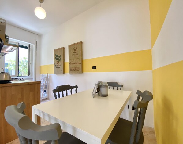 A dining area with a table, chairs, and a window.