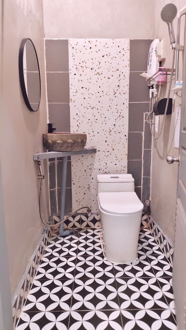 A small bathroom with a toilet, a sink, and a shower.