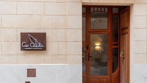 Ein Hotel Eingang mit einer Holztür und einem Schild, auf dem 'Cas Català - Tourism Interior' steht.