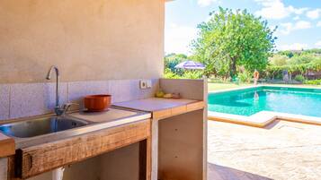 Cocina con lavamanos y vista a una piscina.