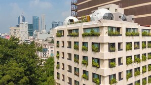 A modern building with multiple floors, large windows, and greenery growing in window boxes. - Umbral | Sky Domes in Roma Norte (Tonali) (Ciudad de México)