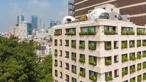 Un bâtiment moderne à plusieurs étages, doté de grandes fenêtres et agrémenté de plantes vertes cultivées dans des jardinières.