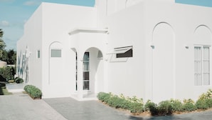 Un edificio moderno blanco con ventanas arqueadas y techo plano.