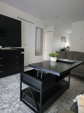 A modern living room with a black coffee table, a grey sofa, and a black entertainment unit. - 2 BR / Modern & Bright / Near Downtown Bellingham (Bellingham)