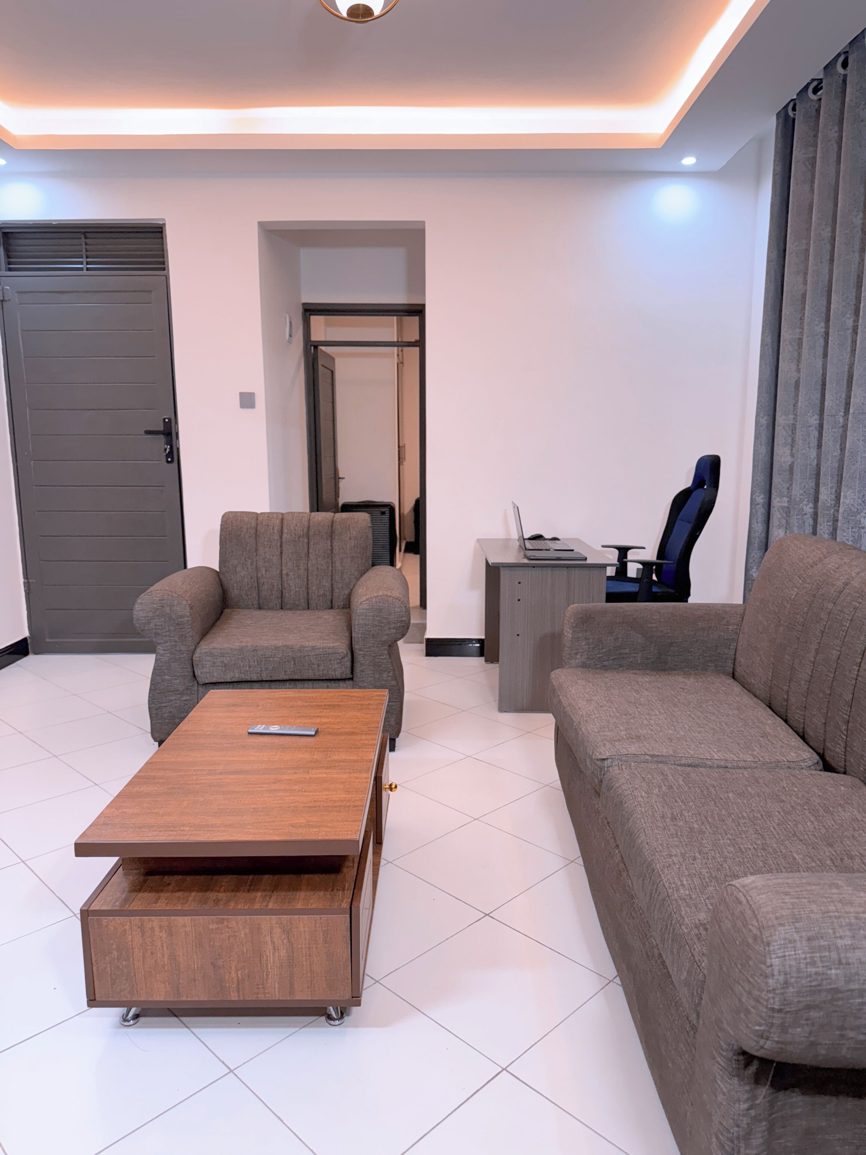 A modern living room with a sofa, a coffee table, and a gaming chair.