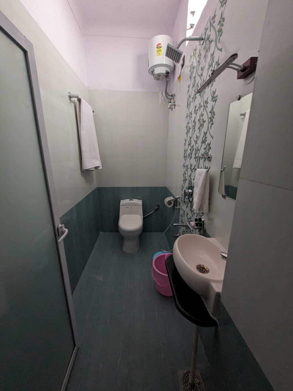 A compact bathroom with a toilet, sink, and shower.