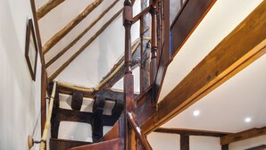 A wooden staircase with a handrail, a rope handrail, and a wooden ceiling with exposed beams. - 2 bedroom accommodation in Kings Lynn (Kings Lynn)