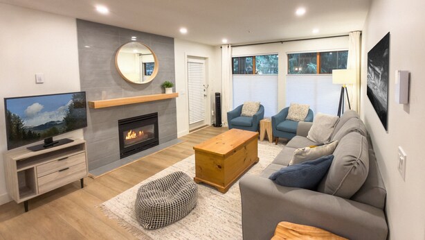 Una sala de estar moderna con chimenea, televisor, sofá y mesa de centro.