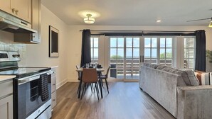 A modern kitchen with a dining area and a sofa. - City Overlook w/ Pool & Extra Large Balcony (Birmingham)