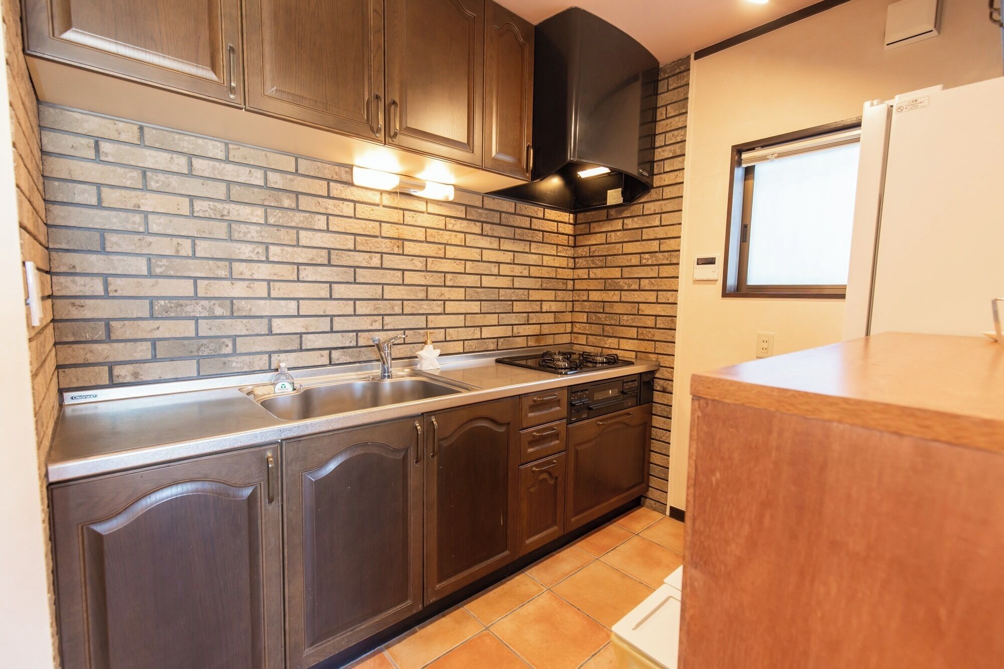 Een koelkast, een magnetron, een kookplaat, kookgerei, borden en bestek