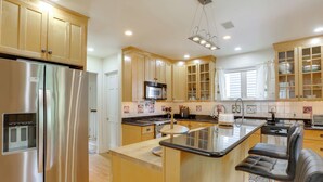 Una cocina moderna con armarios de madera, electrodomésticos de acero inoxidable y una isla central con asientos.