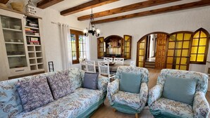A living room with a sofa, two armchairs, a dining table, and a kitchen in the background. - Casa Marsa - Calonge, Catalonia (Calonge)