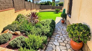 A courtyard with a stone pathway, various shrubs, and a small lawn. - Casa Marsa - Calonge, Catalonia (Calonge)