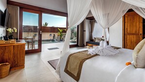 Une chambre spacieuse avec un grand lit, un bureau en bois et un balcon offrant une vue dégagée.