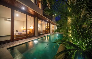 Un hôtel moderne doté d’une piscine, de grandes fenêtres et de plantes d’intérieur.