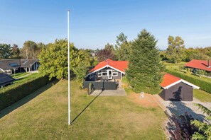 Et boligområde med huse, et flagstang og en velplejet græsplæne.
