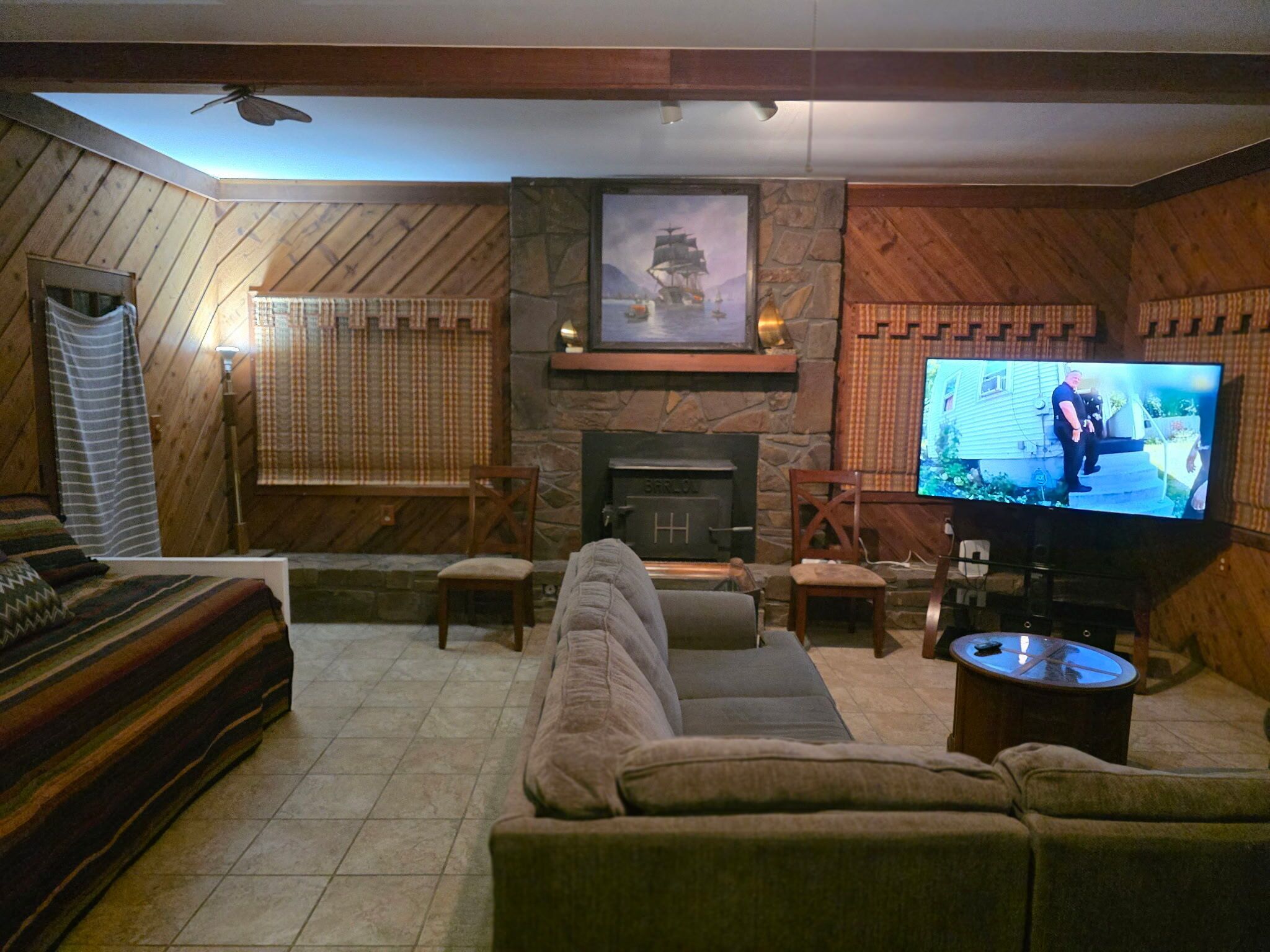A cozy living room with a fireplace, a television, and a large sofa.